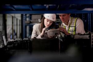 comprobación y inspeccionando metal máquina parte artículos para envío. masculino y mujer trabajador comprobación el Tienda fábrica. industria fábrica depósito. el almacén de de repuesto parte para maquinaria y vehículos foto