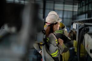 ingenieros cheque controlar pesado máquina robot brazo. diverso equipo de industrial robótica ingenieros reunido alrededor máquina. profesional maquinaria operadores reparar eléctrico robot en brillante digital panel. foto