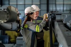 engineers check control heavy machine robot arm. Diverse Team of Industrial Robotics Engineers Gathered Around Machine. Professional Machinery Operators repair electric robot on bright digital panel. photo
