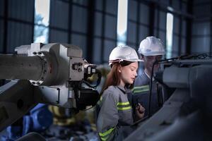 engineers check control heavy machine robot arm. Diverse Team of Industrial Robotics Engineers Gathered Around Machine. Professional Machinery Operators repair electric robot on bright digital panel. photo