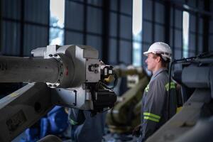 engineers check control heavy machine robot arm. Diverse Team of Industrial Robotics Engineers Gathered Around Machine. Professional Machinery Operators repair electric robot on bright digital panel. photo