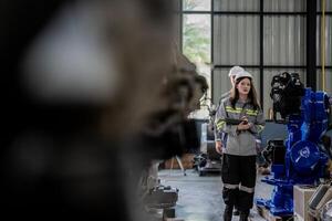 engineers check control heavy machine robot arm. Diverse Team of Industrial Robotics Engineers Gathered Around Machine. Professional Machinery Operators repair electric robot on bright digital panel. photo