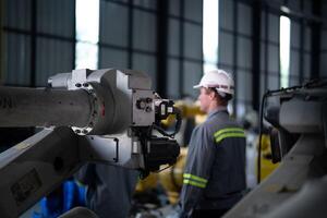 engineers check control heavy machine robot arm. Diverse Team of Industrial Robotics Engineers Gathered Around Machine. Professional Machinery Operators repair electric robot on bright digital panel. photo