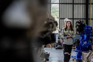 engineers check control heavy machine robot arm. Diverse Team of Industrial Robotics Engineers Gathered Around Machine. Professional Machinery Operators repair electric robot on bright digital panel. photo