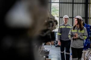 engineers check control heavy machine robot arm. Diverse Team of Industrial Robotics Engineers Gathered Around Machine. Professional Machinery Operators repair electric robot on bright digital panel. photo