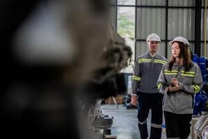 engineers check control heavy machine robot arm. Diverse Team of Industrial Robotics Engineers Gathered Around Machine. Professional Machinery Operators repair electric robot on bright digital panel. photo