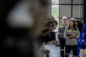 engineers check control heavy machine robot arm. Diverse Team of Industrial Robotics Engineers Gathered Around Machine. Professional Machinery Operators repair electric robot on bright digital panel. photo