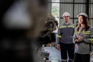engineers check control heavy machine robot arm. Diverse Team of Industrial Robotics Engineers Gathered Around Machine. Professional Machinery Operators repair electric robot on bright digital panel. photo