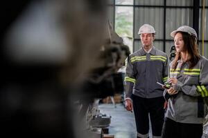 engineers check control heavy machine robot arm. Diverse Team of Industrial Robotics Engineers Gathered Around Machine. Professional Machinery Operators repair electric robot on bright digital panel. photo