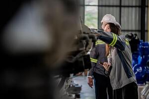 engineers check control heavy machine robot arm. Diverse Team of Industrial Robotics Engineers Gathered Around Machine. Professional Machinery Operators repair electric robot on bright digital panel. photo