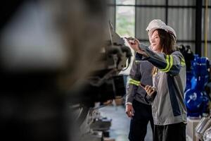engineers check control heavy machine robot arm. Diverse Team of Industrial Robotics Engineers Gathered Around Machine. Professional Machinery Operators repair electric robot on bright digital panel. photo