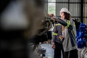 engineers check control heavy machine robot arm. Diverse Team of Industrial Robotics Engineers Gathered Around Machine. Professional Machinery Operators repair electric robot on bright digital panel. photo