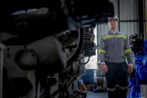 Factory engineer woman inspecting on machine with smart tablet. Worker works at machine robot arm. The welding machine with a remote system in an industrial factory. Artificial intelligence concept. photo