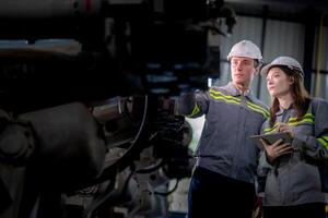 engineers check control heavy machine robot arm. Diverse Team of Industrial Robotics Engineers Gathered Around Machine. Professional Machinery Operators repair electric robot on bright digital panel. photo