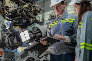 engineers check control heavy machine robot arm. Diverse Team of Industrial Robotics Engineers Gathered Around Machine. Professional Machinery Operators repair electric robot on bright digital panel. photo
