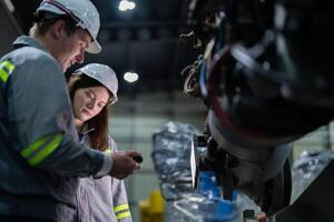 engineers check control heavy machine robot arm. Diverse Team of Industrial Robotics Engineers Gathered Around Machine. Professional Machinery Operators repair electric robot on bright digital panel. photo