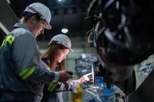 engineers check control heavy machine robot arm. Diverse Team of Industrial Robotics Engineers Gathered Around Machine. Professional Machinery Operators repair electric robot on bright digital panel. photo