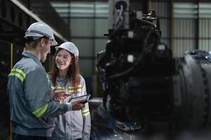 engineers check control heavy machine robot arm. Diverse Team of Industrial Robotics Engineers Gathered Around Machine. Professional Machinery Operators repair electric robot on bright digital panel. photo