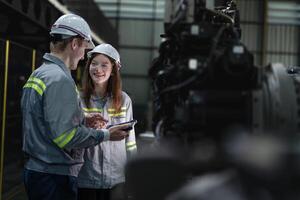 engineers check control heavy machine robot arm. Diverse Team of Industrial Robotics Engineers Gathered Around Machine. Professional Machinery Operators repair electric robot on bright digital panel. photo