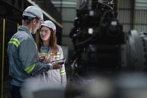 engineers check control heavy machine robot arm. Diverse Team of Industrial Robotics Engineers Gathered Around Machine. Professional Machinery Operators repair electric robot on bright digital panel. photo