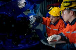 negocio ingenieros reunirse y cheque controlar pesado máquina robot brazo. diverso equipo de industrial robótica ingenieros reunido alrededor máquina. profesional maquinaria operador utilizar industrial digital tableta. foto