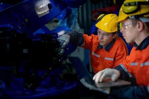 negocio ingenieros reunirse y cheque controlar pesado máquina robot brazo. diverso equipo de industrial robótica ingenieros reunido alrededor máquina. profesional maquinaria operador utilizar industrial digital tableta. foto