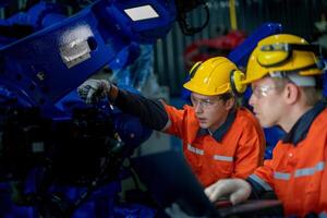 negocio ingenieros reunirse y cheque controlar pesado máquina robot brazo. diverso equipo de industrial robótica ingenieros reunido alrededor máquina. profesional maquinaria operador utilizar industrial digital tableta. foto