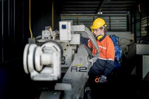 ingeniero hombre comprobación el estado de máquina y usado llave inglesa a tornillo algunos parte de equipo a cnc fábrica. trabajador vistiendo la seguridad lentes y casco. mantenimiento y reparando concepto. foto