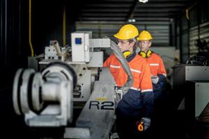 masculino ingeniero trabajadores mantenimiento automático robótico brazo máquina en un fábrica. trabajador comprobación y reparando automático robot mano máquina. técnico trabajador cheque para reparar fábrica máquina. foto