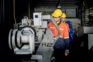 male engineer workers maintenance automatic robotic arm machine in a factory. worker checking and repairing automatic robot hand machine. technician worker check for repair factory machine. photo
