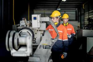 male engineer workers maintenance automatic robotic arm machine in a factory. worker checking and repairing automatic robot hand machine. technician worker check for repair factory machine. photo