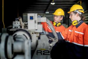 male engineer workers maintenance automatic robotic arm machine in a factory. worker checking and repairing automatic robot hand machine. technician worker check for repair factory machine. photo