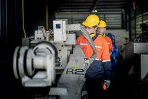 male engineer workers maintenance automatic robotic arm machine in a factory. worker checking and repairing automatic robot hand machine. technician worker check for repair factory machine. photo