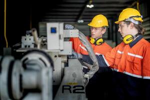 male engineer workers maintenance automatic robotic arm machine in a factory. worker checking and repairing automatic robot hand machine. technician worker check for repair factory machine. photo