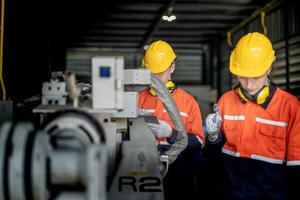 male engineer workers maintenance automatic robotic arm machine in a factory. worker checking and repairing automatic robot hand machine. technician worker check for repair factory machine. photo