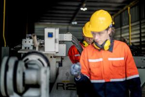 ingeniero hombre comprobación el estado de máquina y usado llave inglesa a tornillo algunos parte de equipo a cnc fábrica. trabajador vistiendo la seguridad lentes y casco. mantenimiento y reparando concepto. foto