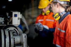 masculino ingeniero trabajadores mantenimiento automático robótico brazo máquina en un fábrica. trabajador comprobación y reparando automático robot mano máquina. técnico trabajador cheque para reparar fábrica máquina. foto