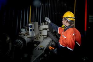 ingeniero hombre comprobación el estado de máquina y usado llave inglesa a tornillo algunos parte de equipo a cnc fábrica. trabajador vistiendo la seguridad lentes y casco. mantenimiento y reparando concepto. foto