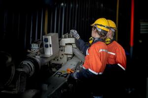 male engineer workers maintenance automatic robotic arm machine in a factory. worker checking and repairing automatic robot hand machine. technician worker check for repair factory machine. photo