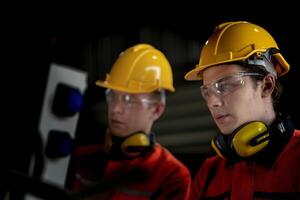 masculino ingeniero trabajadores mantenimiento automático robótico brazo máquina en un fábrica. trabajador comprobación y reparando automático robot mano máquina. técnico trabajador cheque para reparar fábrica máquina. foto