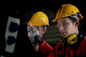 male engineer workers maintenance automatic robotic arm machine in a factory. worker checking and repairing automatic robot hand machine. technician worker check for repair factory machine. photo