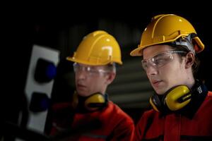 masculino ingeniero trabajadores mantenimiento automático robótico brazo máquina en un fábrica. trabajador comprobación y reparando automático robot mano máquina. técnico trabajador cheque para reparar fábrica máquina. foto