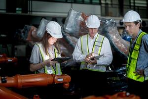 ventas gerente y fábrica propietario en trajes negociando de venta robots usado en el fábrica. negocio ingenieros reunión y comprobación nuevo máquina robot. trabajadores caminando a almacén soldadura máquina. foto