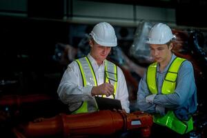 Sales manager and factory owner in suits negotiating selling robots used in the factory. Business engineers meeting and checking new machine robot. Workers walking at warehouse welding machine. photo