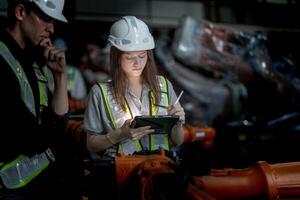 negocio ingenieros reunión y comprobación nuevo máquina robot. trabajadores caminando a almacén industria soldadura máquina. negocio negociación conceptos y tecnología. mujer utilizando inteligente tableta a presente hombre. foto