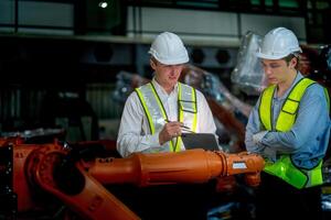 Sales manager and factory owner in suits negotiating selling robots used in the factory. Business engineers meeting and checking new machine robot. Workers walking at warehouse welding machine. photo