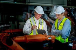 negocio ingenieros reunión y comprobación nuevo máquina robot. trabajadores caminando a almacén industria soldadura máquina. negocio negociación conceptos y tecnología. mujer utilizando inteligente tableta a presente hombre. foto