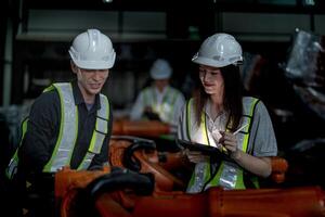 Sales manager and factory owner in suits negotiating selling robots used in the factory. Business engineers meeting and checking new machine robot. Workers walking at warehouse welding machine. photo