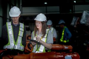 negocio ingenieros reunión y comprobación nuevo máquina robot. trabajadores caminando a almacén industria soldadura máquina. negocio negociación conceptos y tecnología. mujer utilizando inteligente tableta a presente hombre. foto