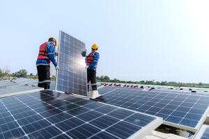 masculino trabajadores reparar flotante solar paneles en agua lago. ingenieros construir en sitio flotante solar paneles a Dom ligero. limpiar energía para futuro viviendo. industrial renovable energía de verde fuerza. foto